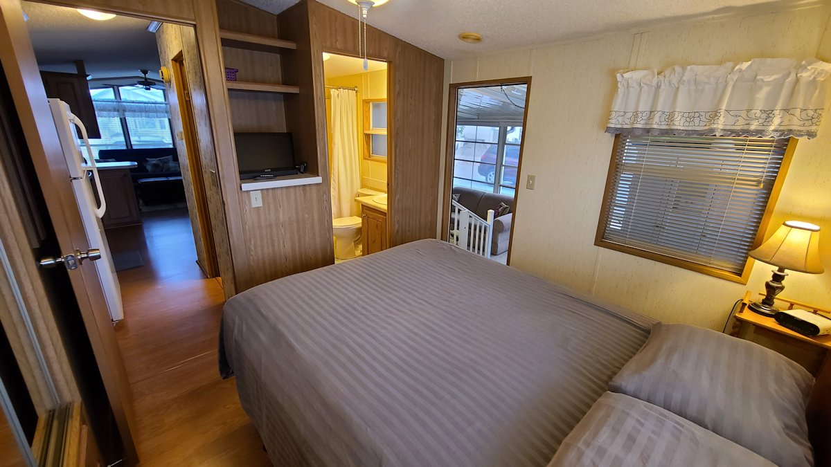 Bedroom has flat screen TV and easy access to bathroom and laundry area.